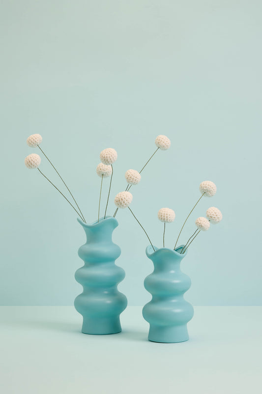 White Craspedia stems in blue vase